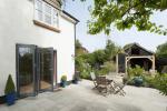 Evolution Storm Windows in cream complimentd with a three part bi fold door leading into the garden